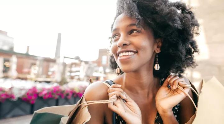 woman smiling with two shopping bags